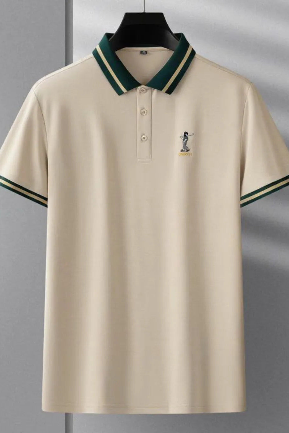 Beige polo shirt with green accents on a hanger against a gray background