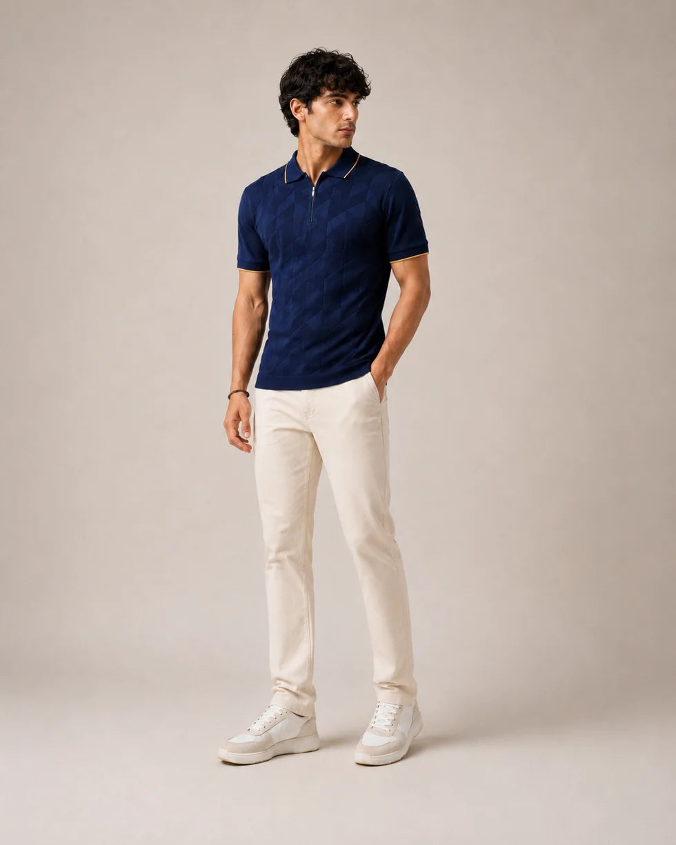 Full-length front view of a model wearing the navy blue with orange trim tonal geometric jacquard polo