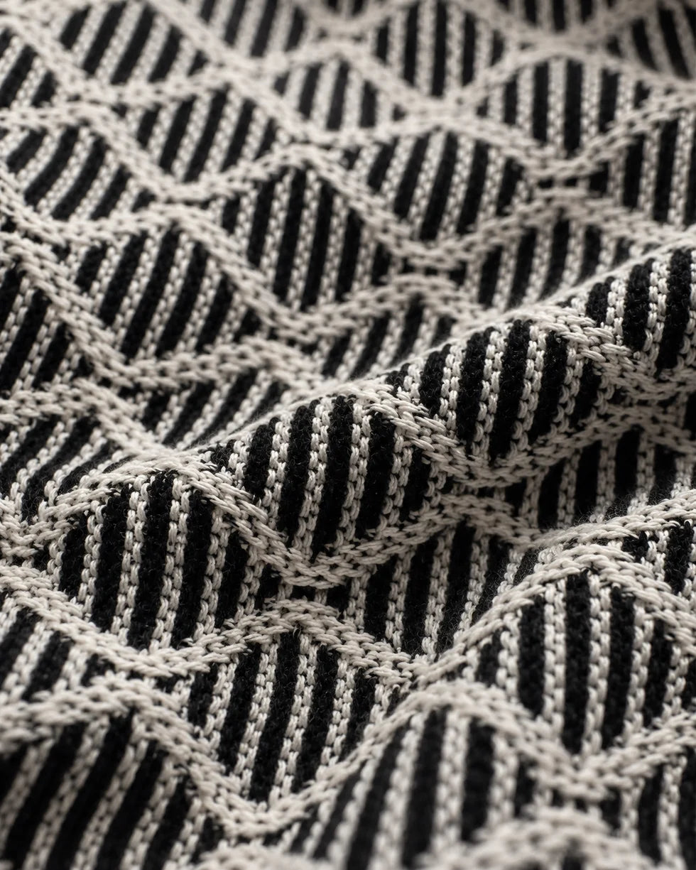 Close-up of the black and white diamond jacquard polo knit texture