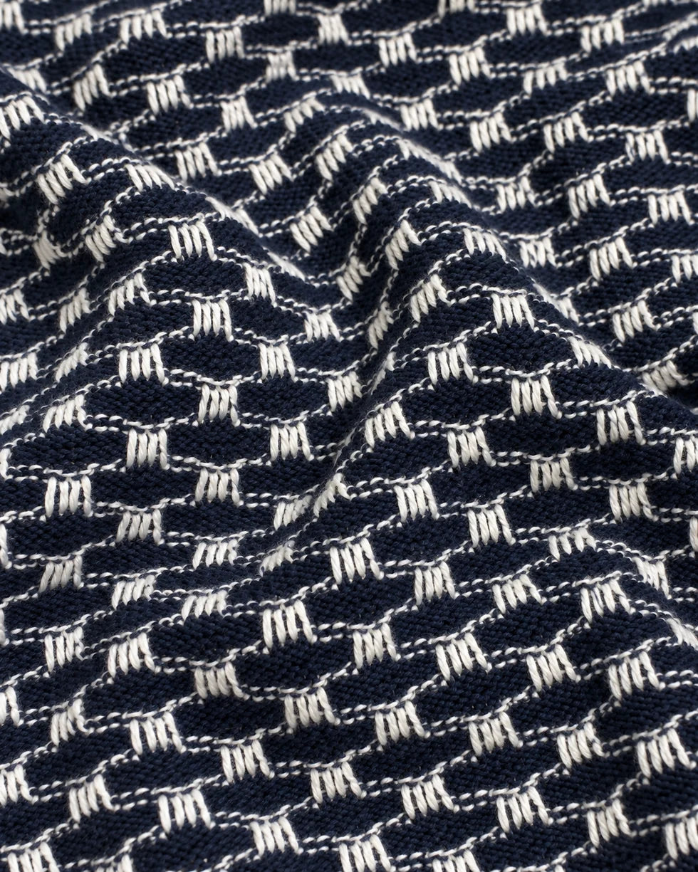 Close-up of the navy and white small-scale geometric jacquard knit texture