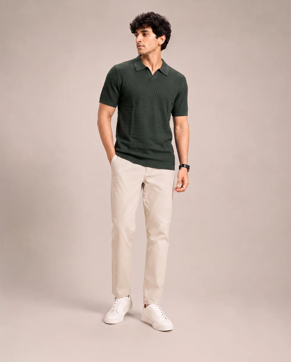Full-length front view of a model wearing the emerald green tonal textured knit polo