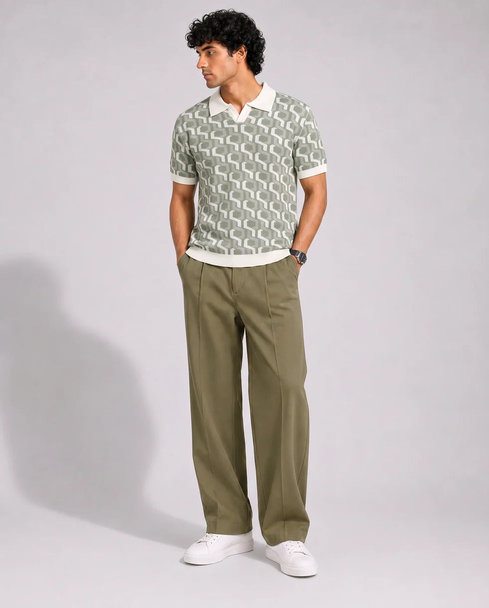 Full-length front view of a model wearing the sage green and off-white interlocking geometric jacquard polo
