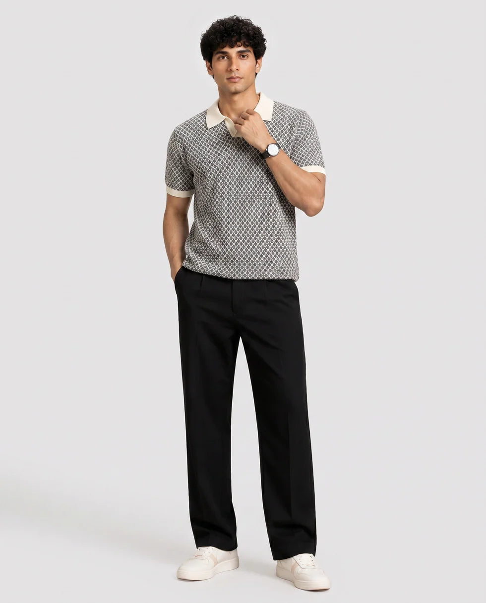Full-length front view of a model wearing the black and white diamond jacquard polo