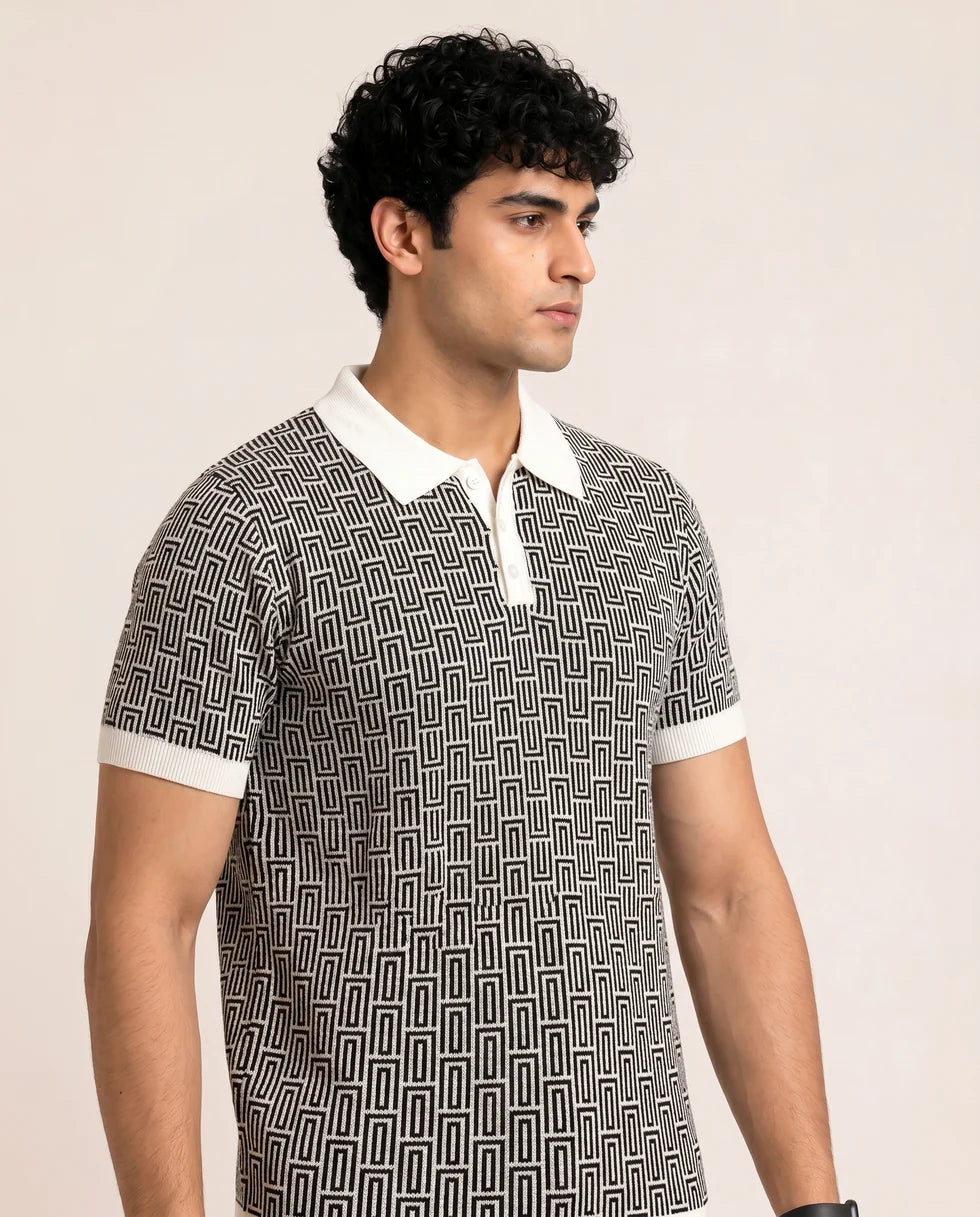 Close front view of the black and white geometric maze jacquard polo showing its polo collar with button placket