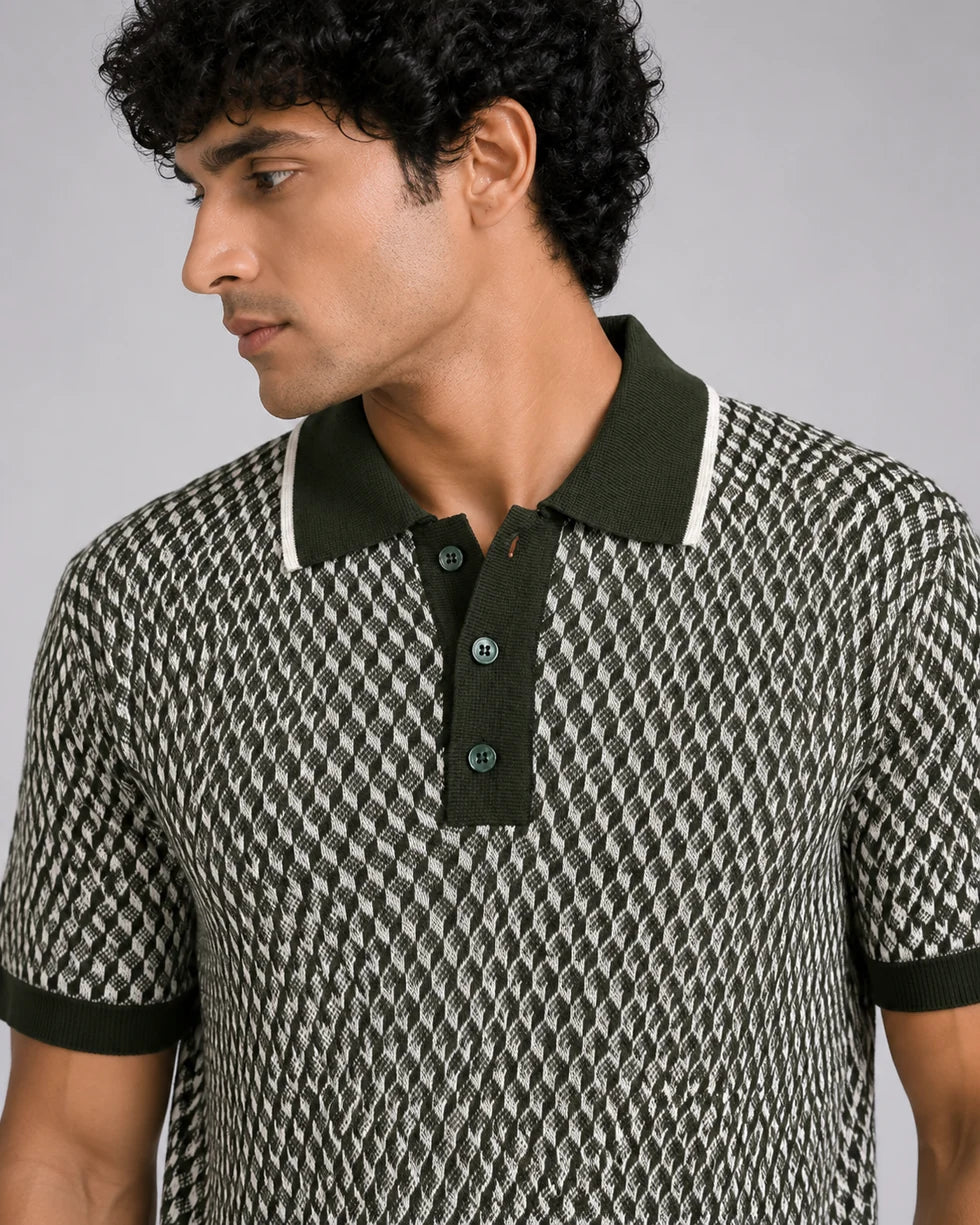 Close front view of the olive green and cream geometric cube jacquard polo showing its polo collar with button placket