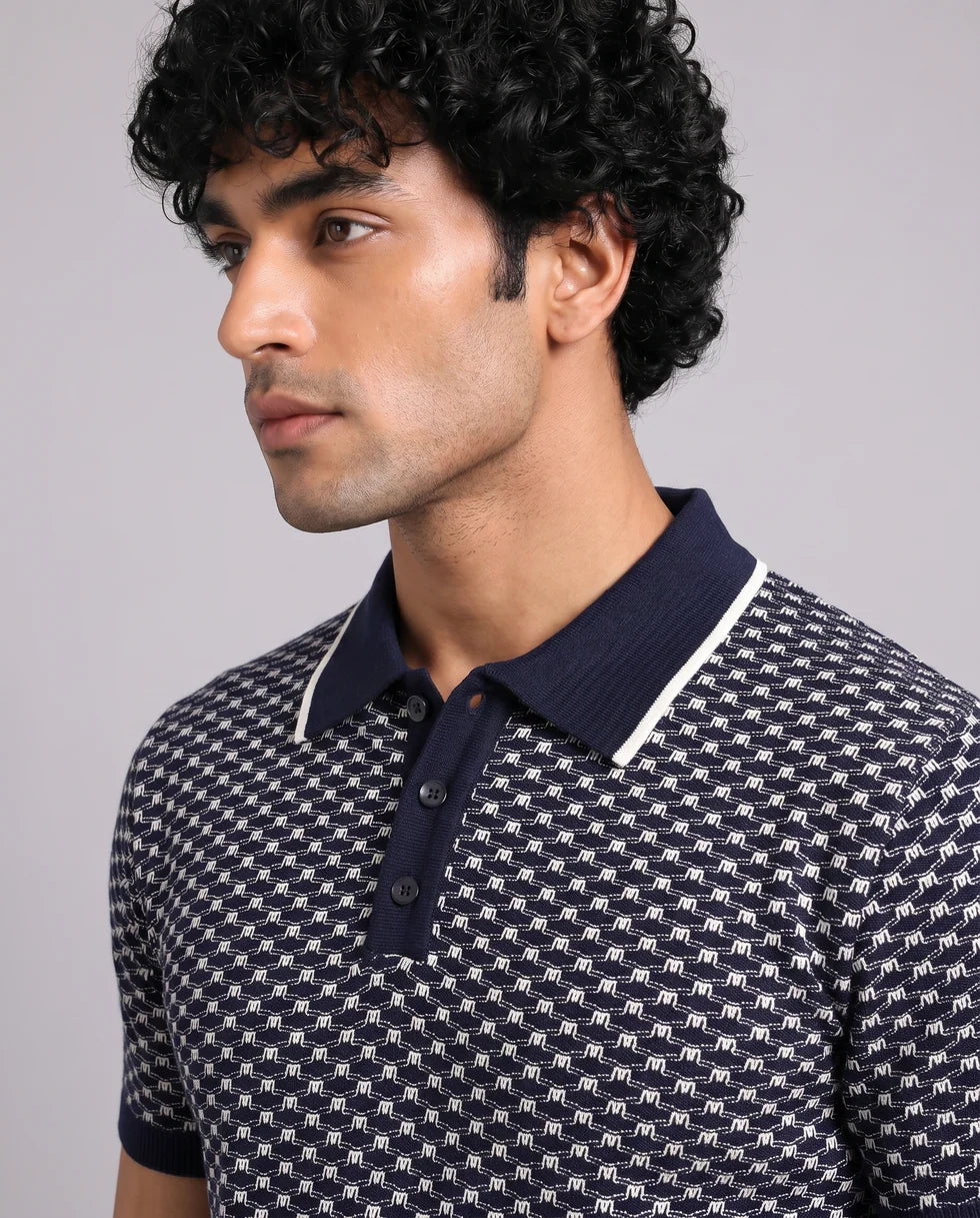 Close front view showing the polo collar with button placket and navy and white small-scale geometric jacquard