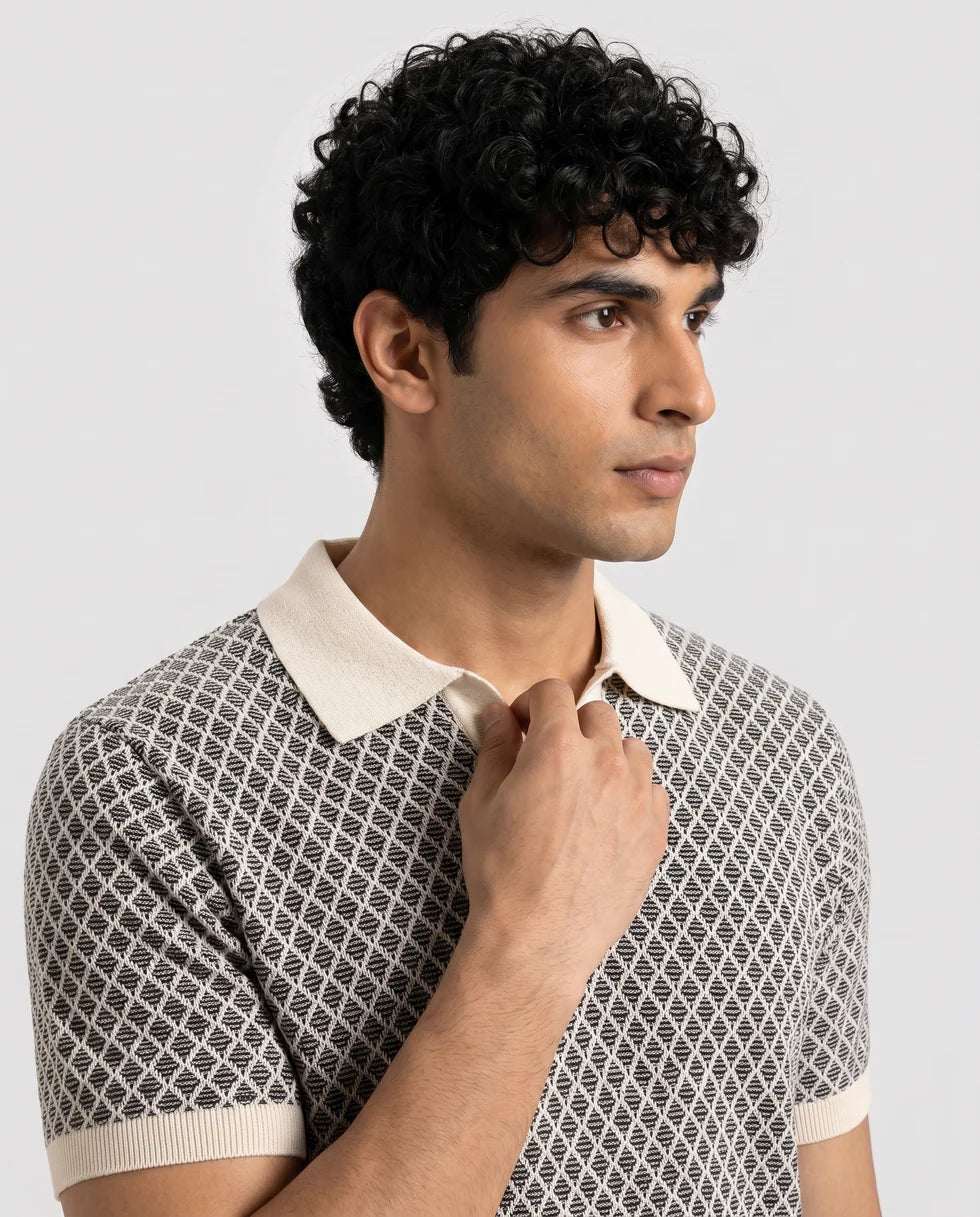 Close front view of the black and white diamond jacquard polo showing its open johnny collar