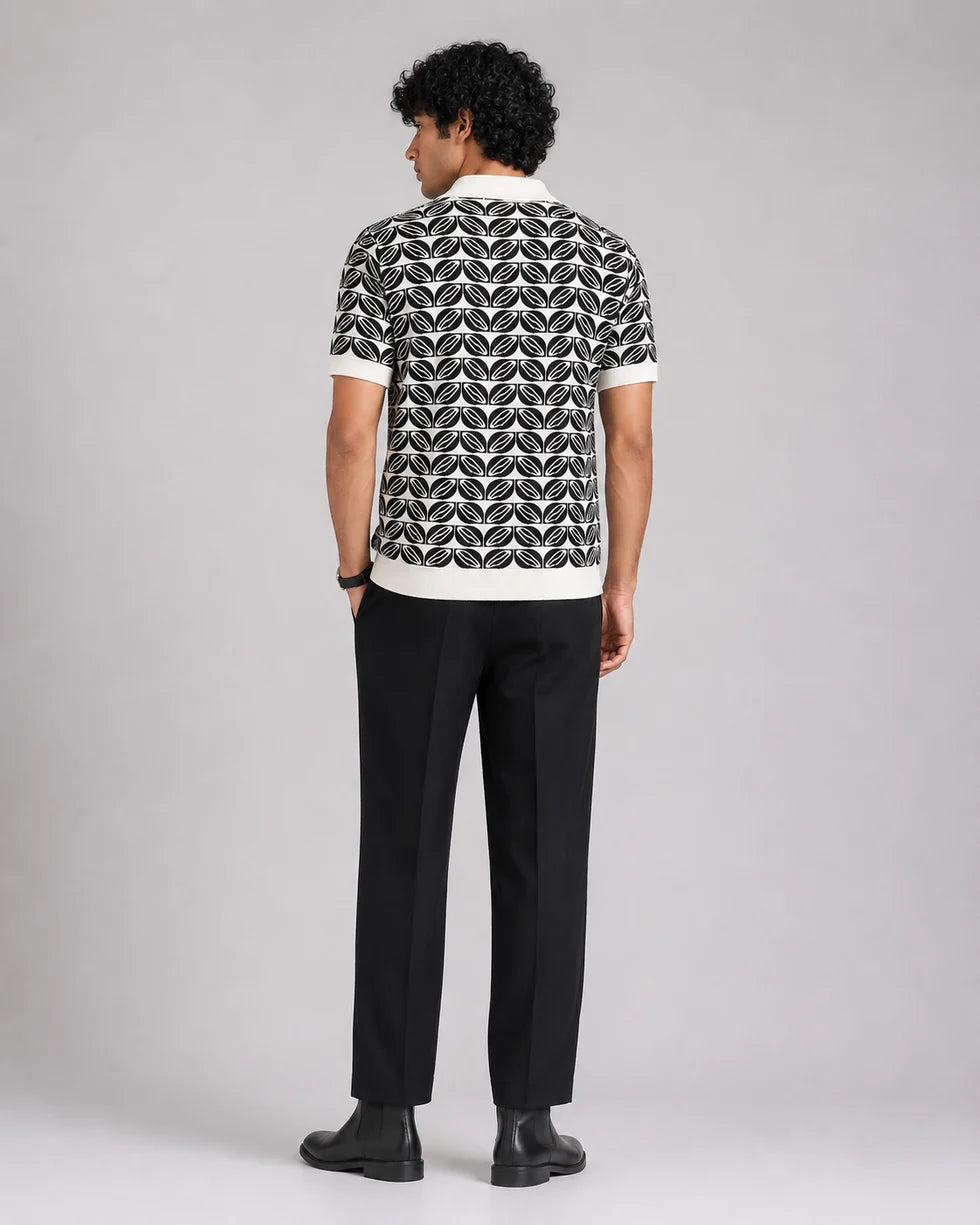Back view of the deep green and white repeating leaf-motif jacquard polo and its short sleeves
