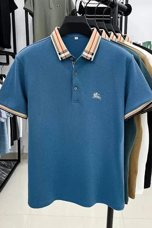 Blue polo shirt with plaid collar on a hanger in a clothing store.