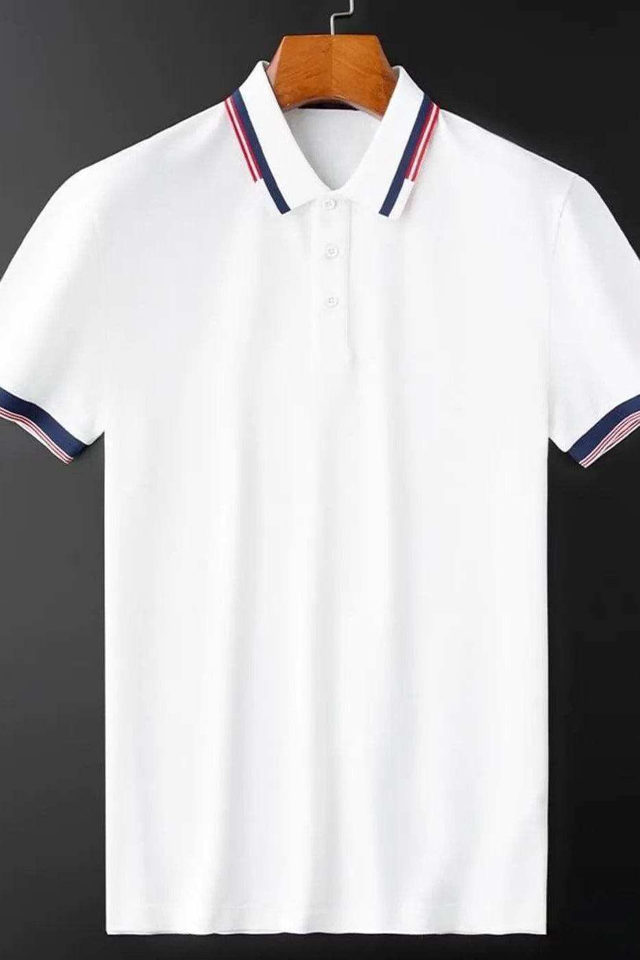 White polo shirt with colorful trim on a hanger against a dark background