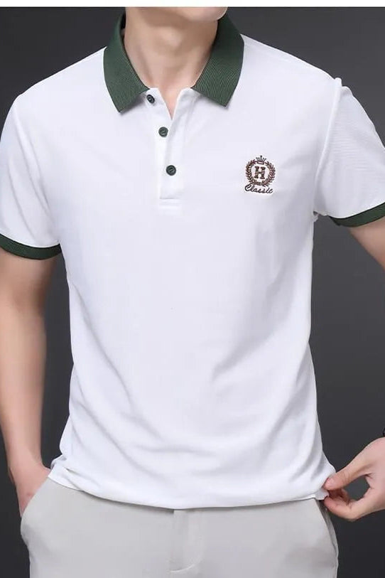 White polo shirt with green accents and a logo on a dark background